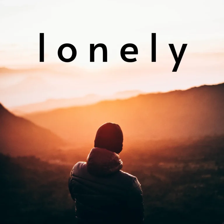 En ung mand sidder alene på en bænk i en park.