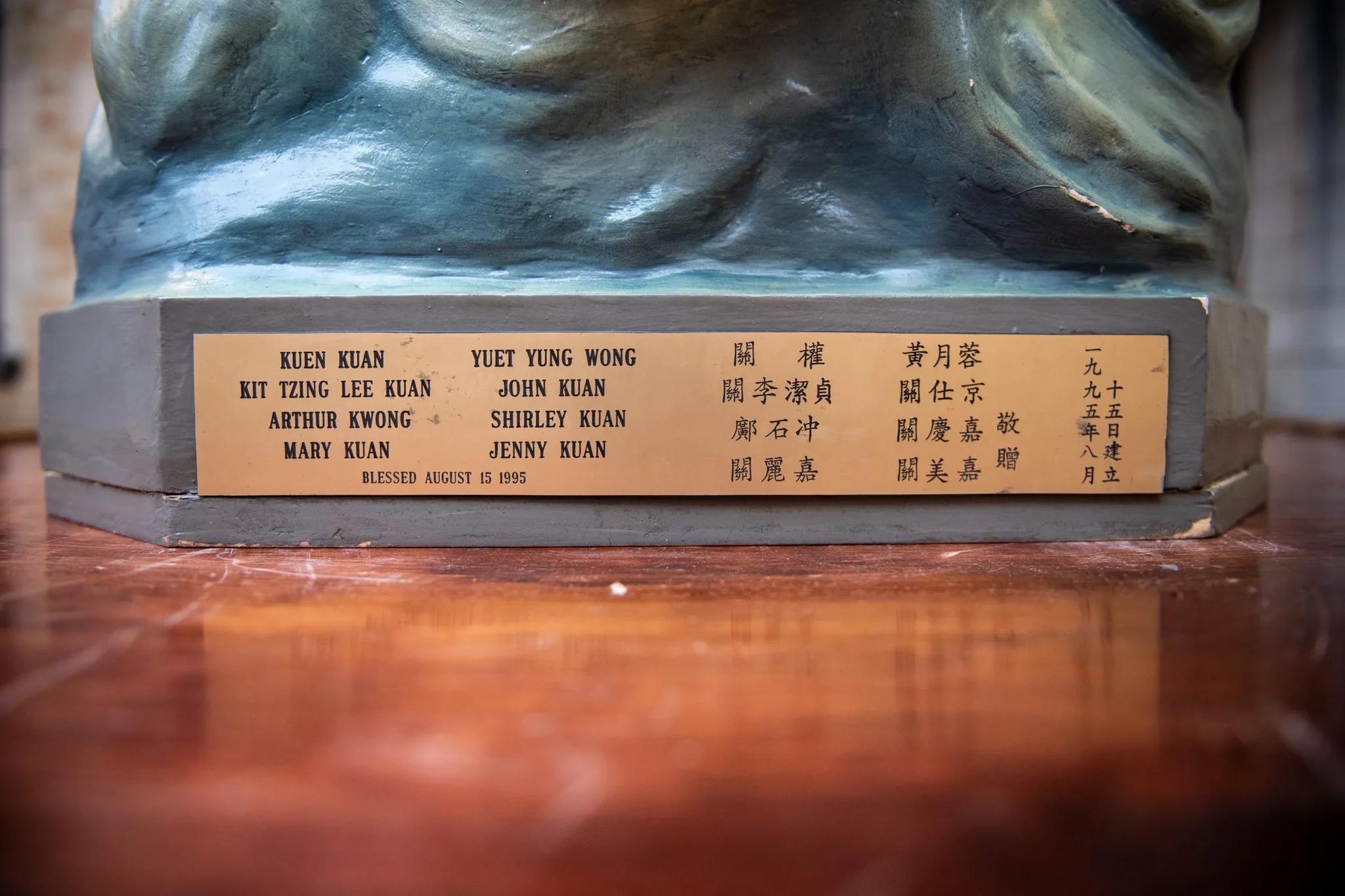 Navnene på de kinesiske katolikker, der bragte traditionen til kirken, står på statuens sokkel.