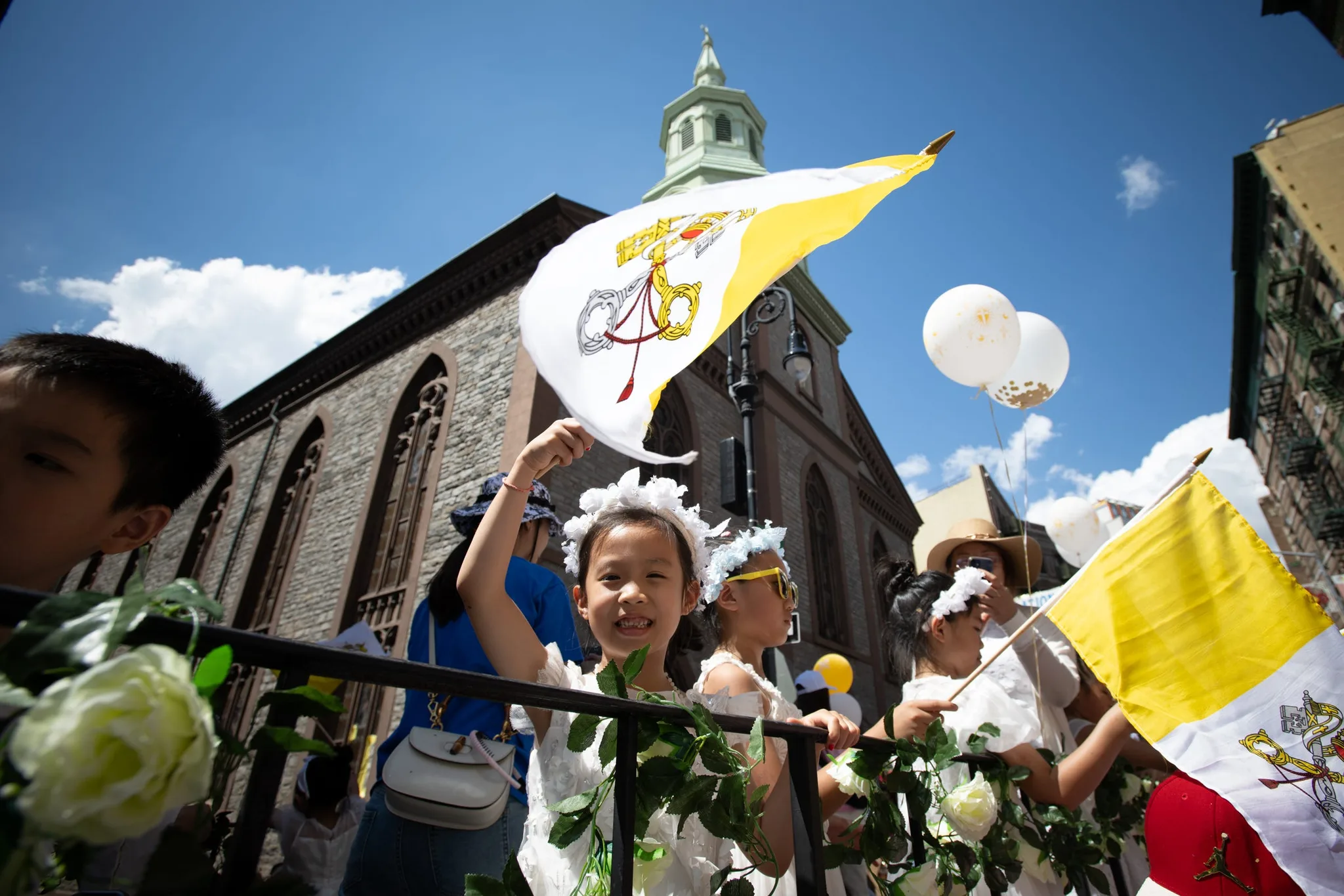 Smilende børn vifter med flag på Mott Street.