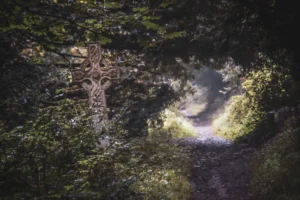 Et naturskjønt syn av et keltisk kors blant frodig grønnskap langs en skogsti i Bristol, England.