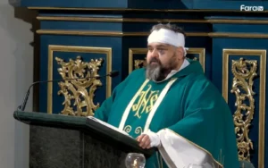 Pastor Adrian Mantykiewicz taler med bandage om hovedet.