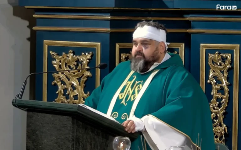 Pastor Adrian Mantykiewicz taler med bandage om hovedet.