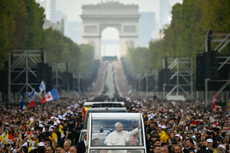 Pave Leo XIV vinker til en stor menneskemængde ved en messe under åben himmel i Paris.