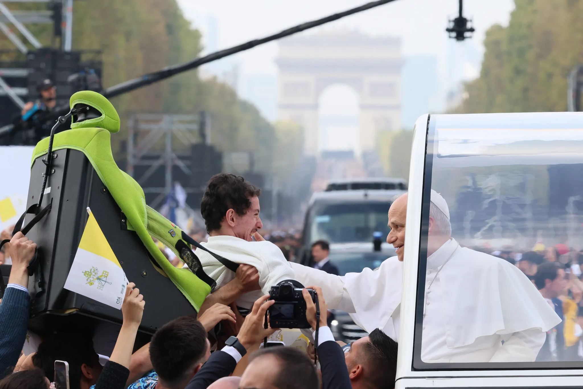 Pave Leo XIV velsigner en mand med et handicap under processionen i Paris.