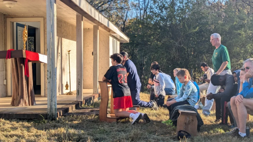 Fædre og sønner beder under eukaristisk tilbedelse på Camp Castleton.