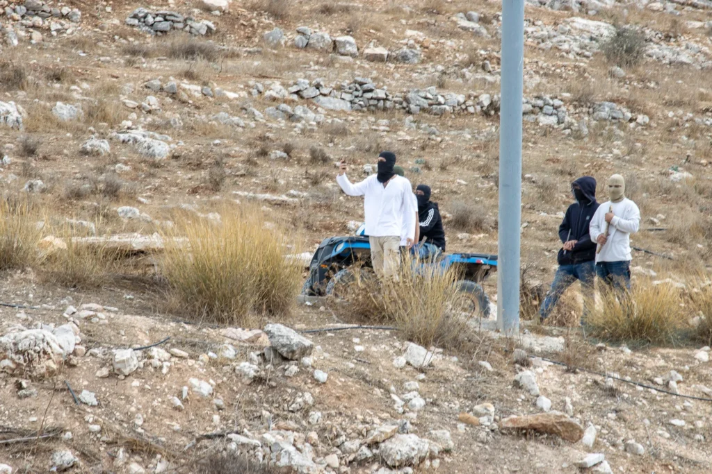 Maskerede bosættere spærrer en vej i Taybeh.