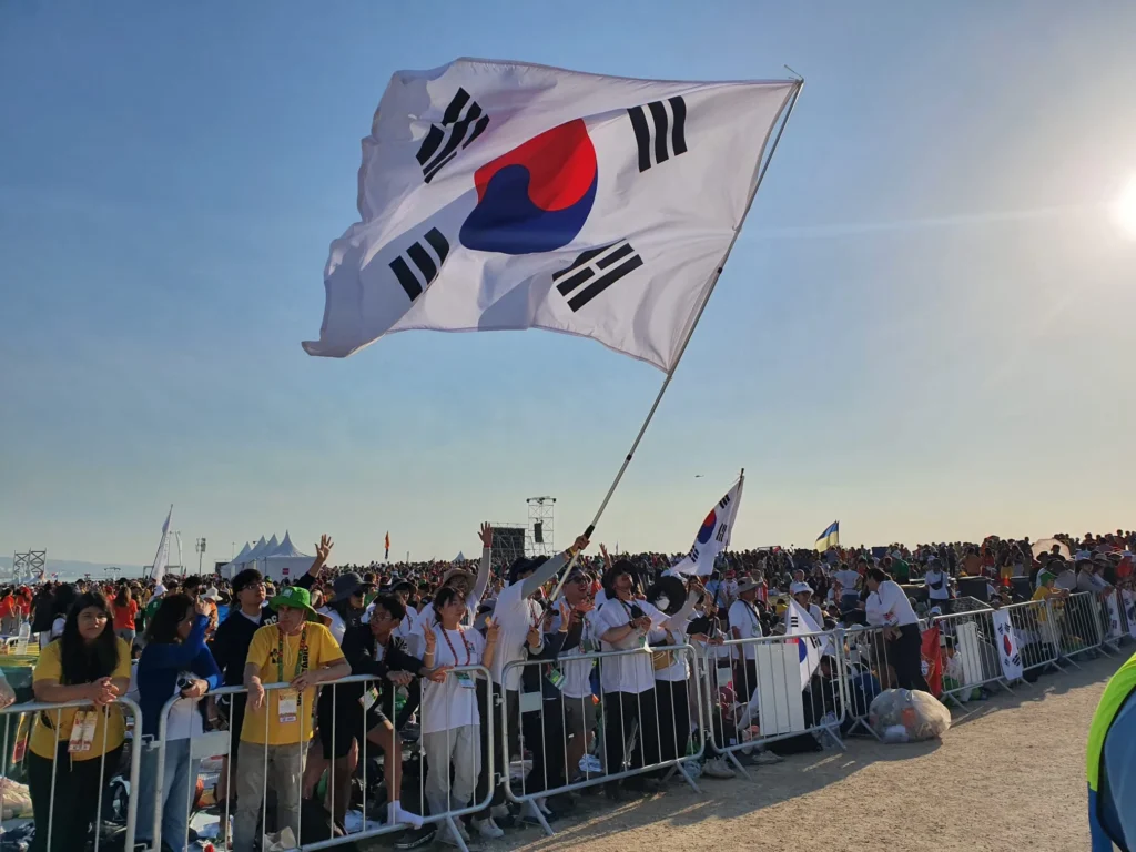 Sydkoreanske pilgrimme vifter med et flag under afslutningsmessen ved Verdensungdomsdagene i Lissabon.