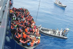 Mandlige migranter venter på registrering hos myndighederne i Dungeness i Kent.