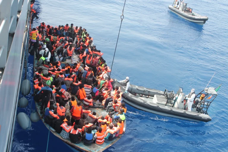 Mandlige migranter venter på registrering hos myndighederne i Dungeness i Kent.