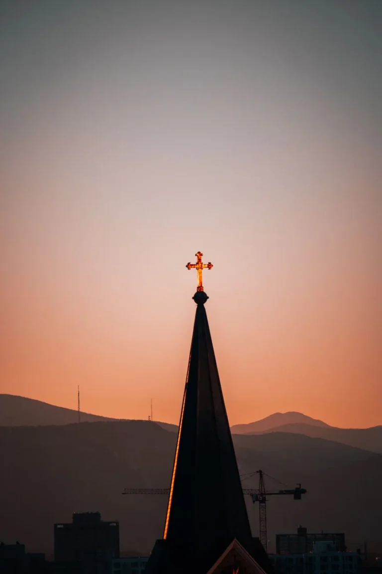 En kirkespire i silhuett mot en levende solnedgang i Denver, Colorado.