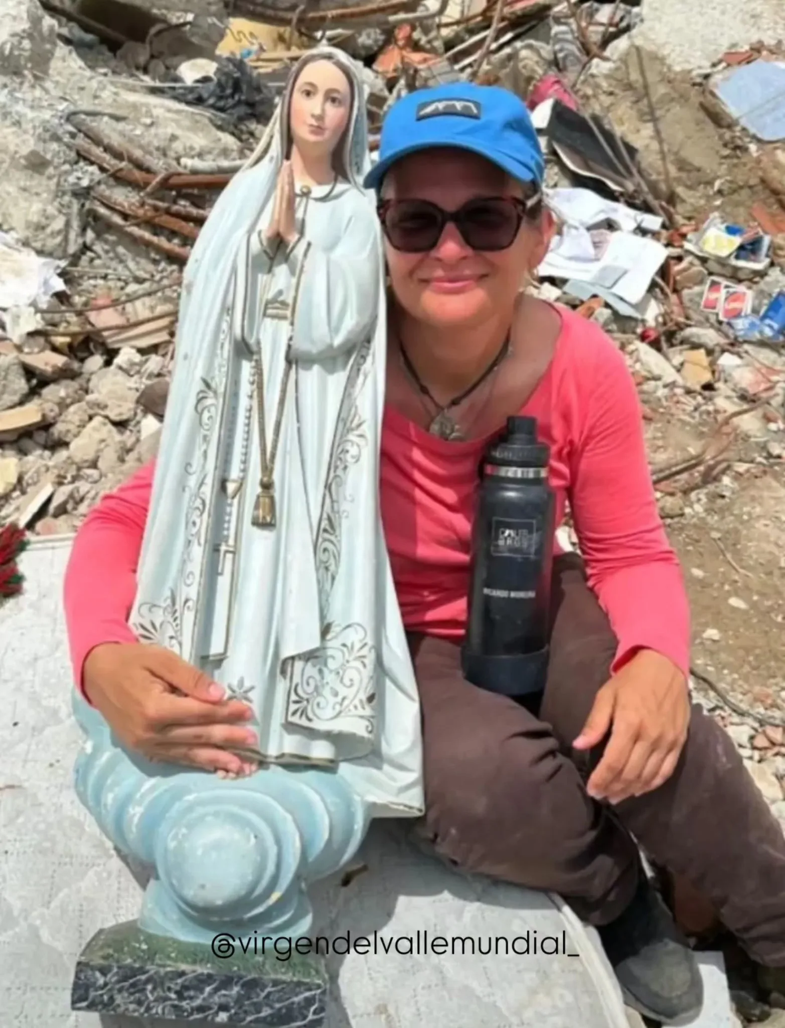 María Elena med en statue af Vor Frue af Fatima, som blev bjærget intakt fra murbrokkerne.
