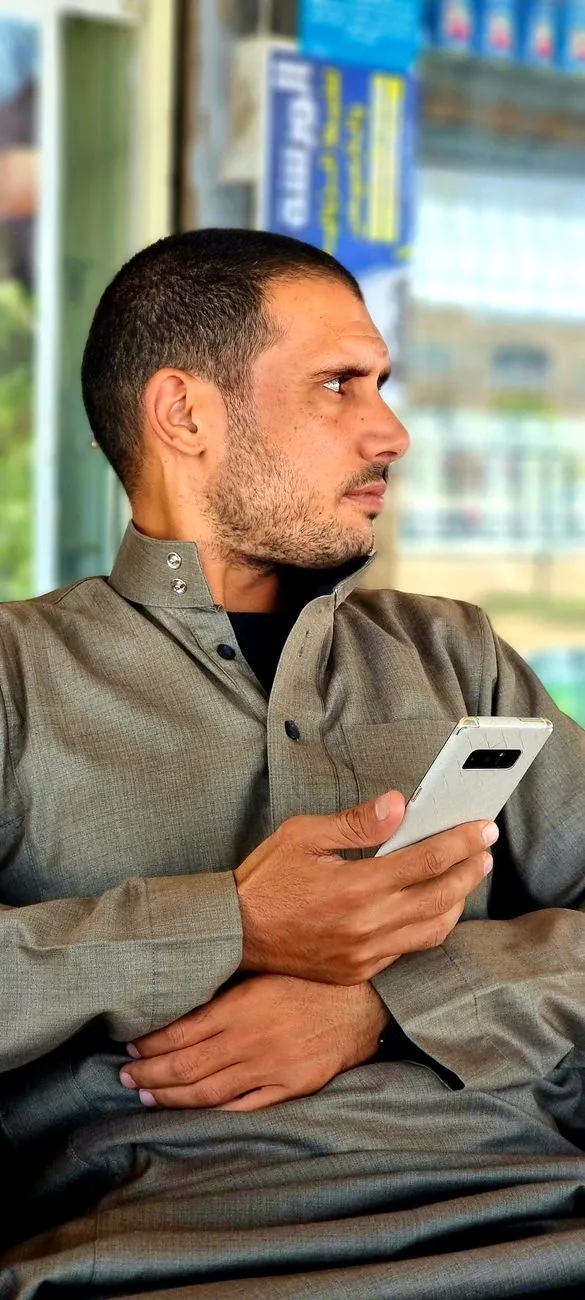 Mann fra Midtøsten bruker en smarttelefon i Egypt, fanget i et candid portrett.