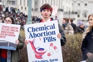 En tilhænger holder et skilt om medicinske abortpillers miljøpåvirkning.