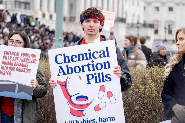 En tilhænger holder et skilt om medicinske abortpillers miljøpåvirkning.