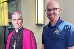 Dr. Shane Rainey med en papfigur af ærkebiskop Fulton J. Sheen.